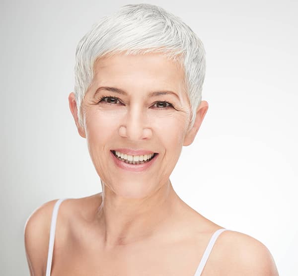 Smiling woman with short white hair
