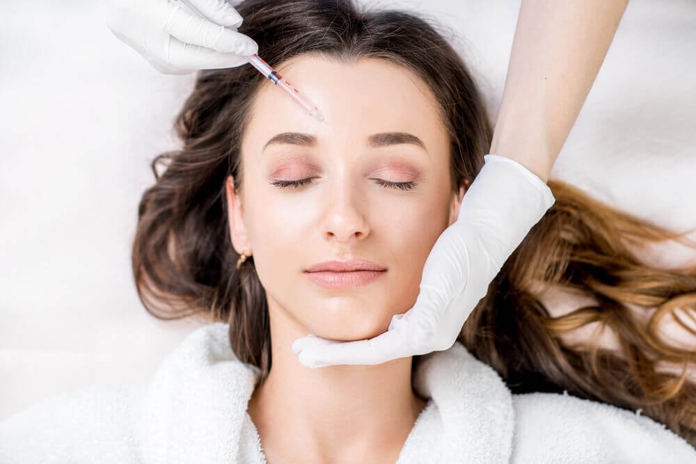 Woman on treatment table getting botox injection