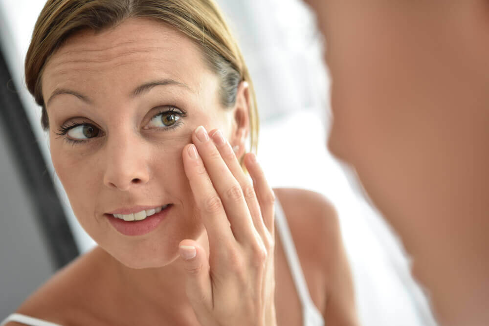 Beautiful woman in her 30s looking in the mirror